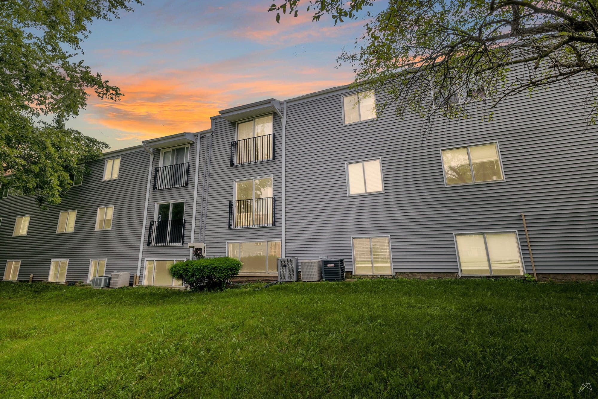 Landscaped grounds and mature trees at The Grove Apartments in North Peoria